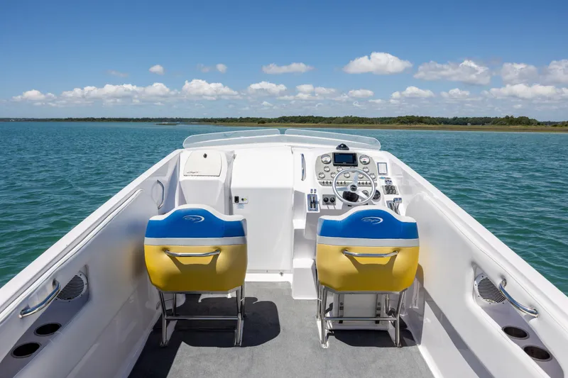 Slide: The Image of 2014 Baja 35 Outlaw boat cockpit with dual seats on a sunny day. - 11