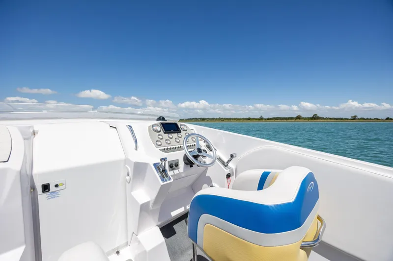 Slide: The Image of Cockpit of 2014 Baja 35 Outlaw boat with blue skies and calm waters. - 15