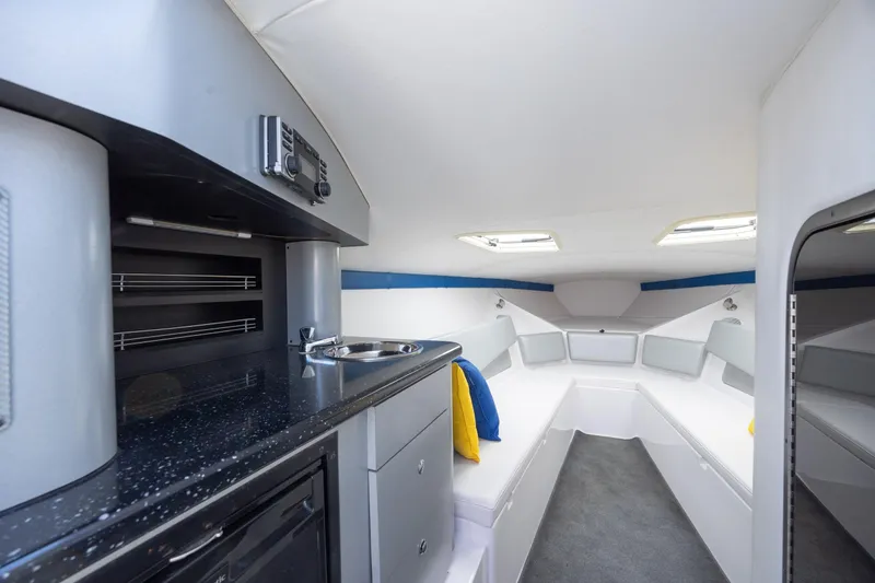 Slide: The Image of Interior of 2014 Baja 35 Outlaw boat with kitchenette and seating area. - 19