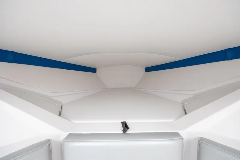 Slide: The Image of Interior cabin of a 2014 Baja 35 Outlaw boat, featuring sleek white and blue design. - 22