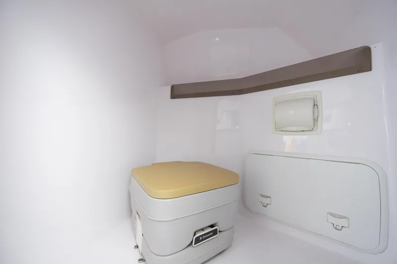 Slide: The Image of Interior of a 2014 Baja 35 Outlaw boat featuring a compact marine toilet. - 24