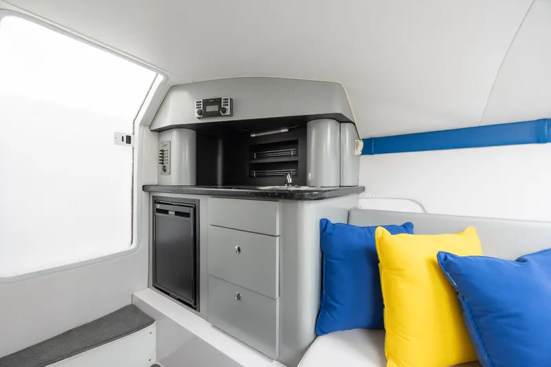 Slide: The Image of Interior of 2014 Baja 35 Outlaw boat with kitchenette and colorful cushions. - 25