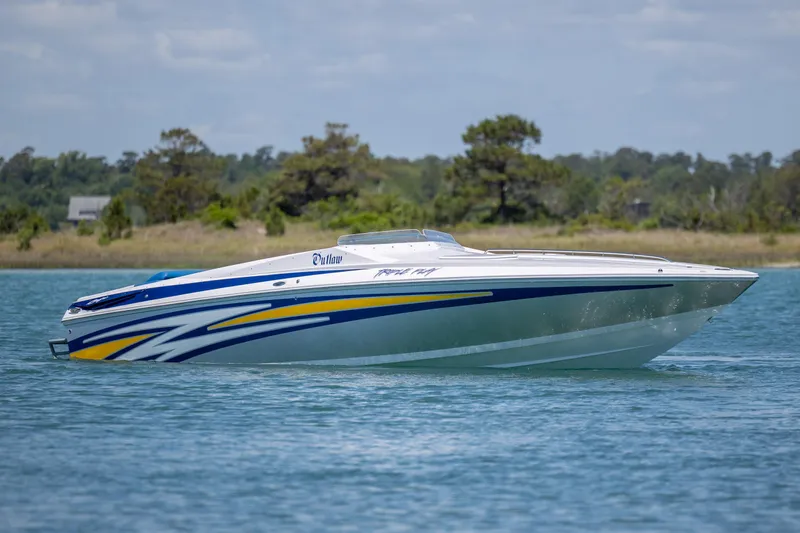 Slide: The Image of 2014 Baja 35 Outlaw speedboat cruising on a serene lake. - 4