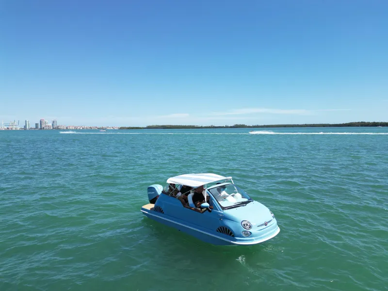 Slide: The Image of Blue Car Off-shore Fiat 500 Classic boat on open water, 2025 model. - 2