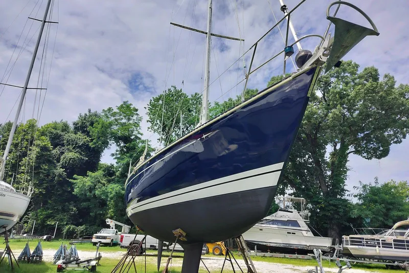 Slide: The Image of 1993 C&C 37/40 XL sailboat on stands, surrounded by trees and other boats. - 1