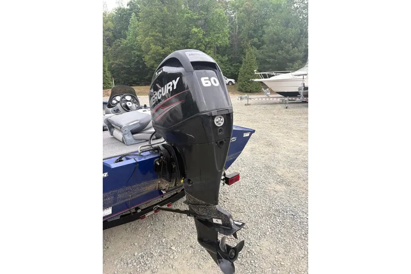 Slide: The Image of 2015 Tracker Pro Team 175 TF boat with Mercury 60 outboard motor in a wooded area. - 7