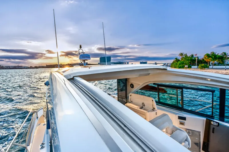 Slide: The Image of 2023 Beneteau Gran Turismo 45 yacht cruising near tropical shoreline at sunset. - 28