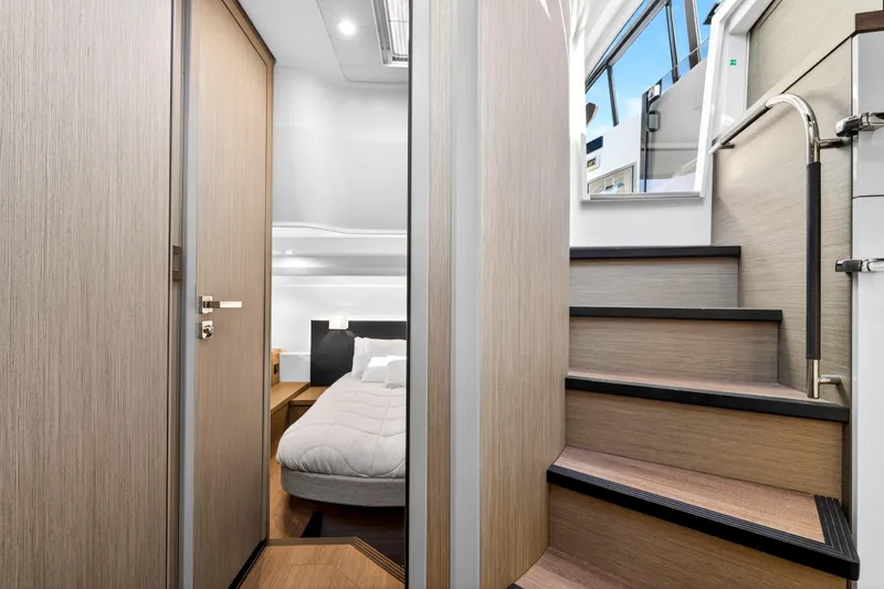 Slide: The Image of Interior of 2023 Beneteau Gran Turismo 45 yacht, featuring a cozy bedroom and sleek staircase. - 30
