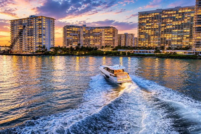 Slide: The Image of 2023 Beneteau Gran Turismo 45 cruising at sunset near illuminated city skyline. - 51