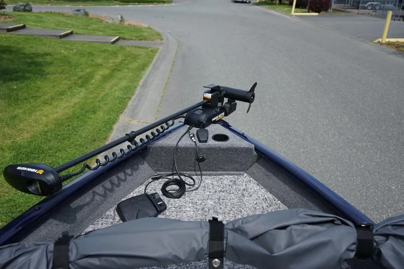 Slide: The Image of 2025 TRACKER BOATS Pro Guide V16 SC with trolling motor on a paved road. - 12