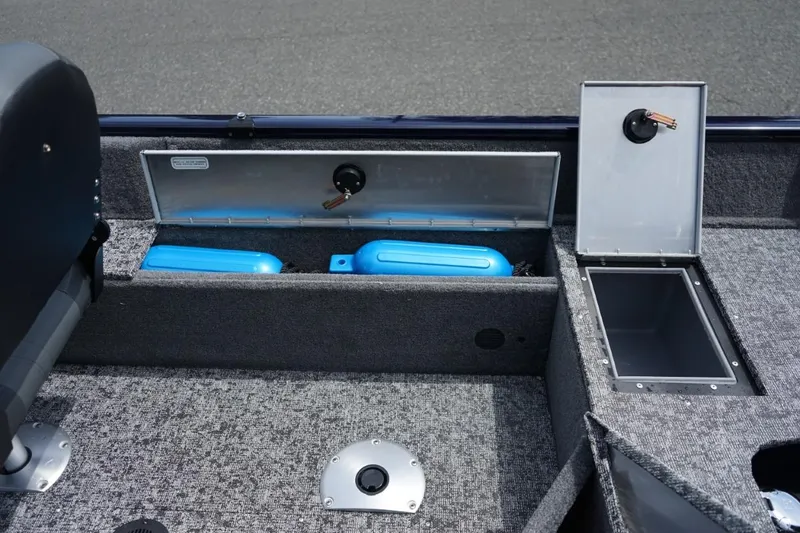 Slide: The Image of 2025 TRACKER BOATS Pro Guide V16 SC interior storage compartments with blue fenders. - 7