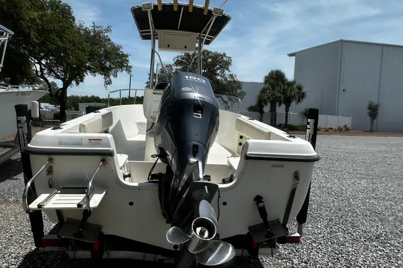 Slide: The Image of 2008 Hydra Sport 212 Lightning boat with outboard motor, parked on gravel lot. - 2
