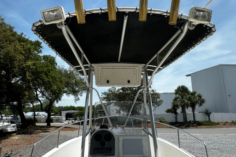 Slide: The Image of 2008 Hydra Sport 212 Lightning boat with T-top and rod holders, parked outdoors. - 7