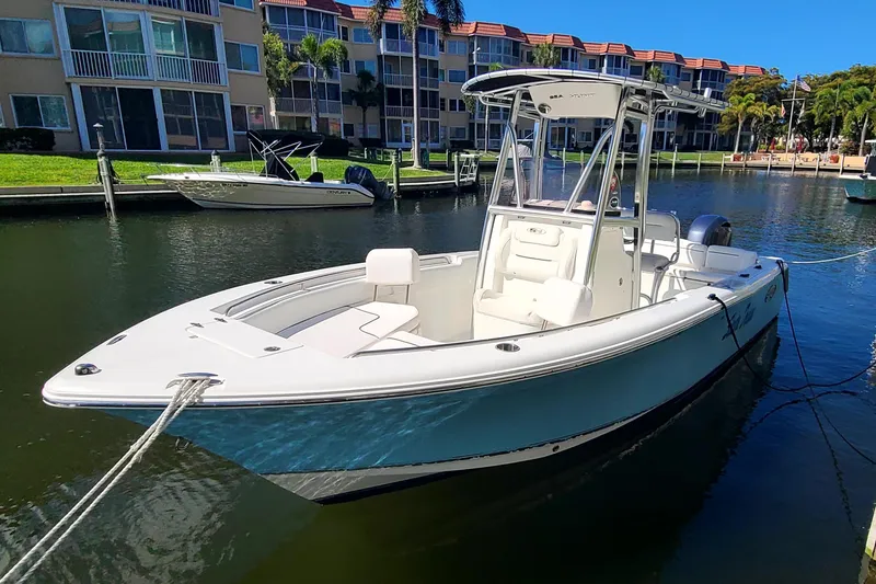 The Image of 2017 Sea Hunt Ultra 225 boat docked in a sunny marina setting. - 0
