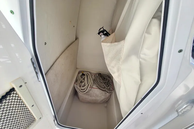 Slide: The Image of Storage compartment of 2017 Sea Hunt Ultra 225 boat with rope and fire extinguisher. - 10