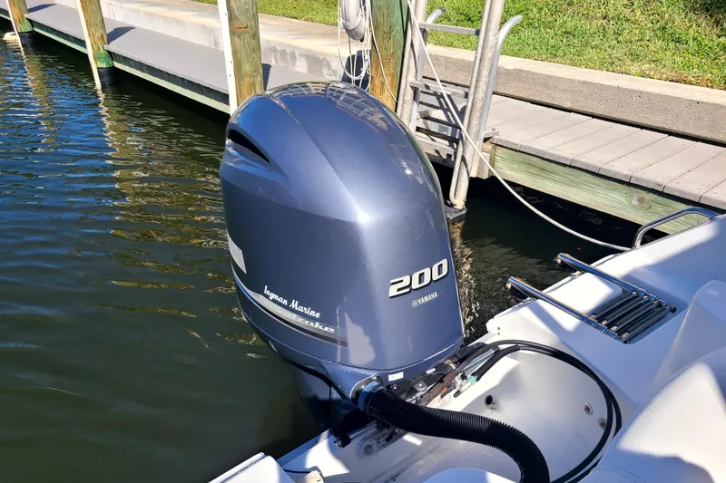 Slide: The Image of Outboard motor on 2017 Sea Hunt Ultra 225 boat docked by wooden pier. - 16