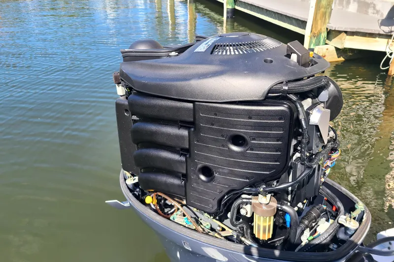 Slide: The Image of Outboard motor of a 2017 Sea Hunt Ultra 225 boat, docked by the water. - 18