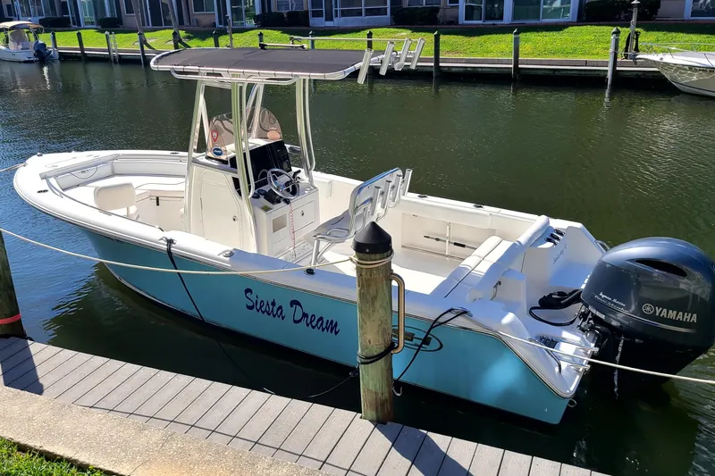 Slide: The Image of 2017 Sea Hunt Ultra 225 boat named "Siesta Dream" docked with Yamaha outboard motor. - 2