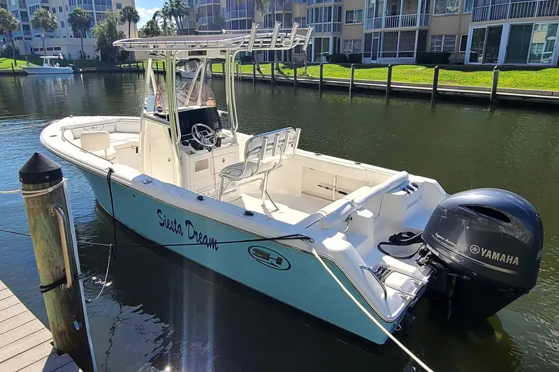 Slide: The Image of 2017 Sea Hunt Ultra 225 boat docked in a serene canal setting. - 3
