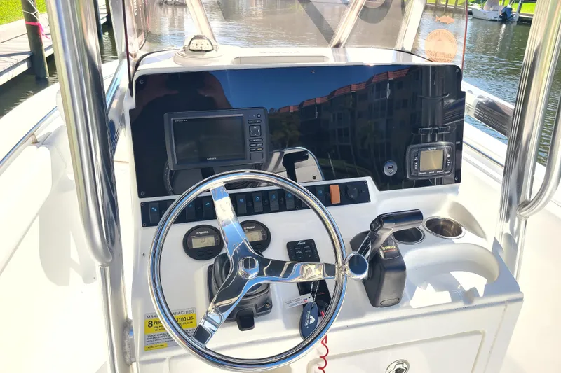 Slide: The Image of 2017 Sea Hunt Ultra 225 boat dashboard with steering wheel and navigation equipment. - 5
