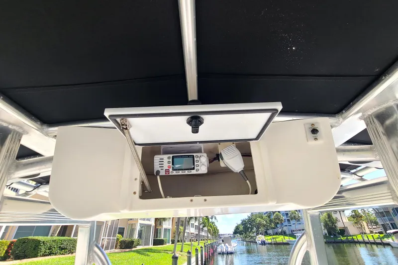Slide: The Image of 2017 Sea Hunt Ultra 225 boat console with radio equipment, dockside view. - 6