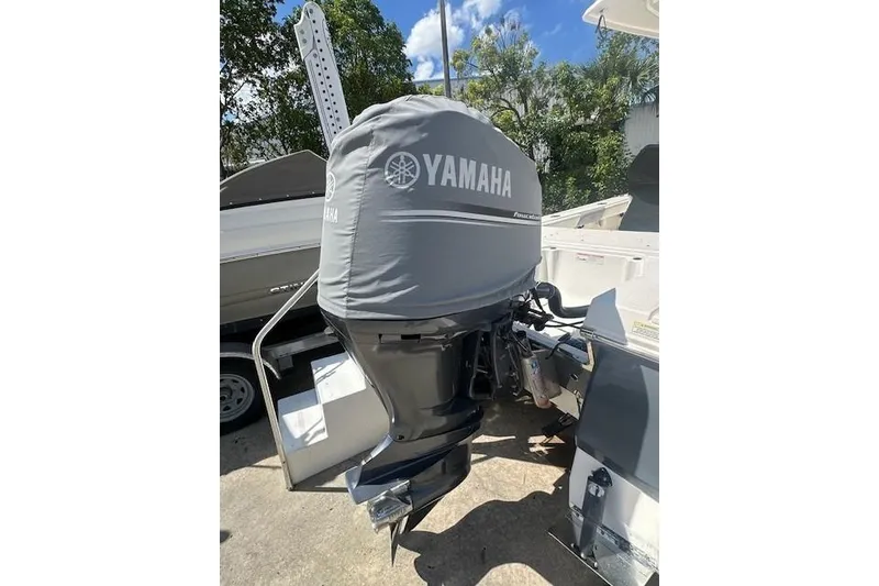 Slide: The Image of 2020 Robalo 246 Cayman boat with Yamaha outboard motor, covered and parked outdoors. - 10