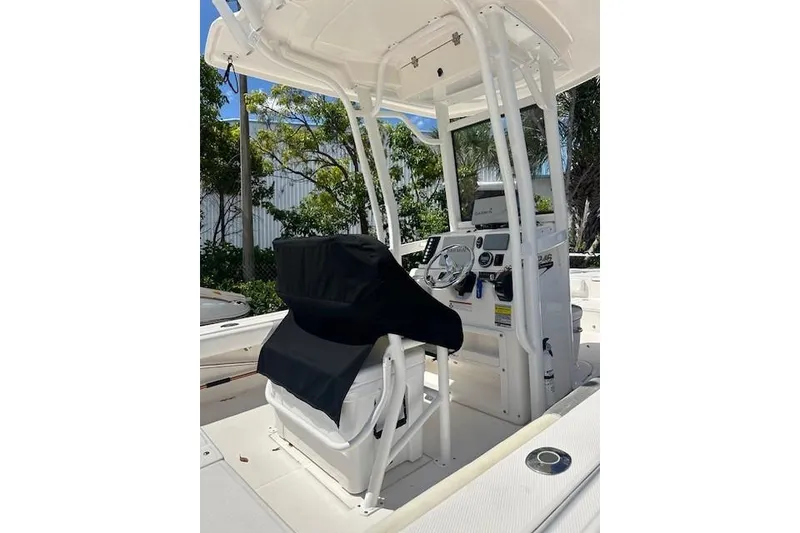 Slide: The Image of 2020 Robalo 246 Cayman boat console with covered seating, steering wheel, and navigation equipment. - 4