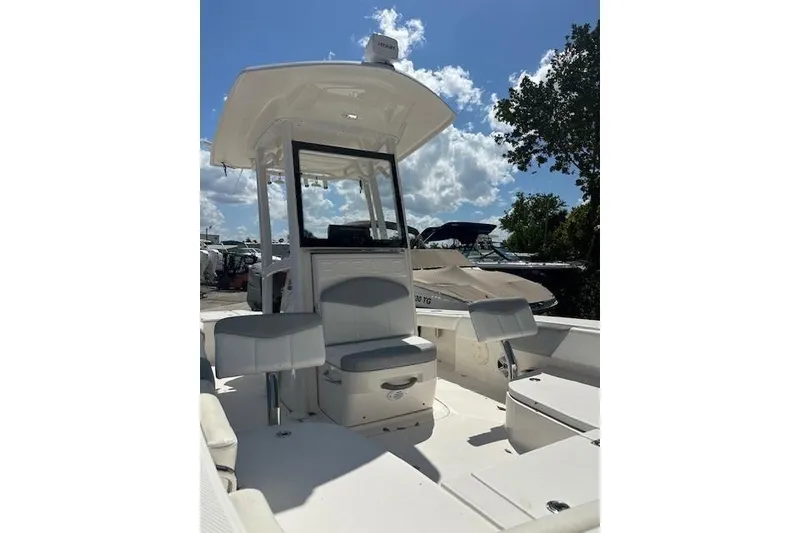 Slide: The Image of 2020 Robalo 246 Cayman boat interior with seating and console under a clear sky. - 5