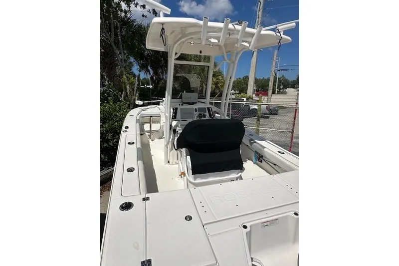 Slide: The Image of 2020 Robalo 246 Cayman boat with center console and T-top under clear sky. - 7