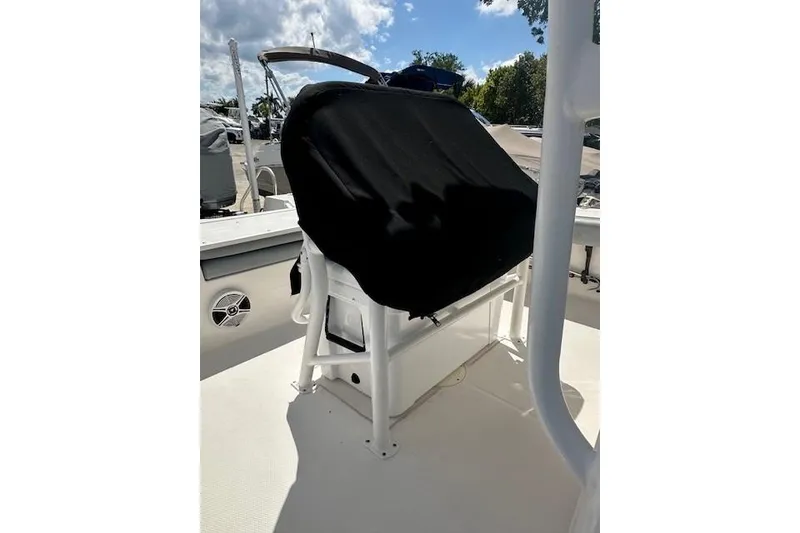 Slide: The Image of 2020 Robalo 246 Cayman boat console covered with black fabric, docked under sunny skies. - 8