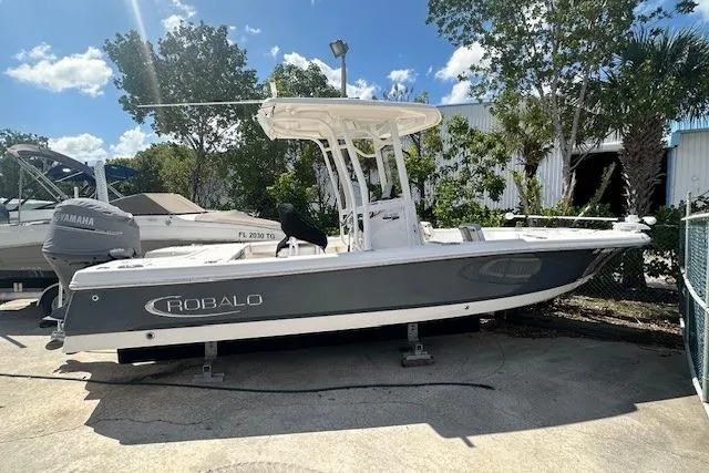Slide: The Image of 2020 Robalo 246 Cayman boat with Yamaha engine, parked outdoors under a clear sky. - 9