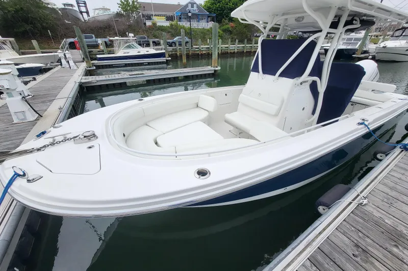Slide: The Image of 2022 Edgewater 245CC boat docked at marina, featuring sleek design and spacious seating. - 10