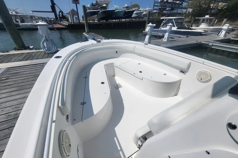 Slide: The Image of 2022 Edgewater 245CC boat interior at marina, showcasing seating and storage. - 11