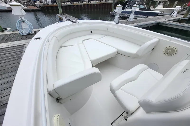 Slide: The Image of 2022 Edgewater 245CC boat with white seating at a marina dock. - 14