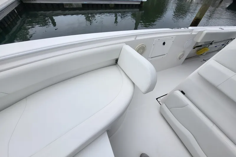 Slide: The Image of 2022 Edgewater 245CC boat interior with white seating and storage compartments. - 15