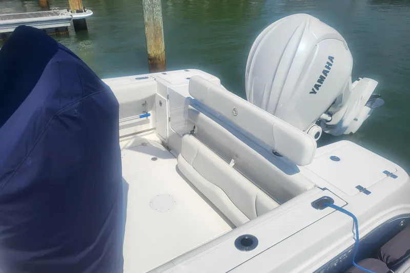 Slide: The Image of 2022 Edgewater 245CC boat with Yamaha engine, docked on calm water. - 16