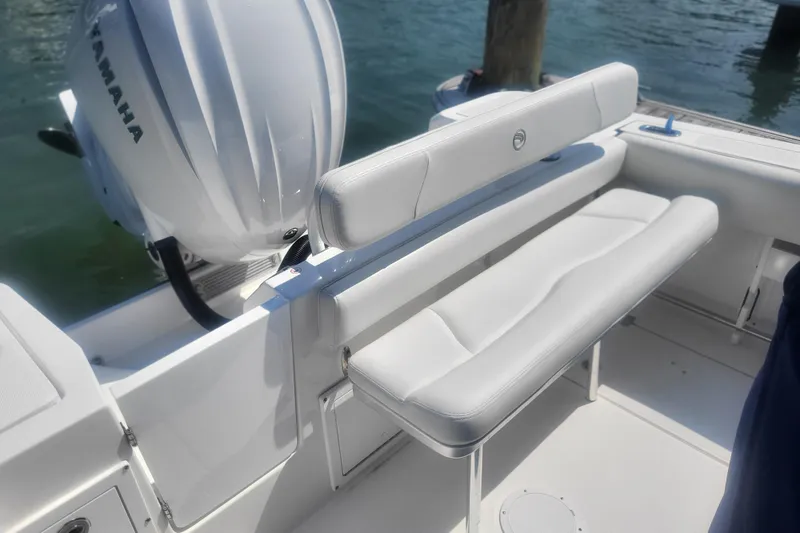 Slide: The Image of 2022 Edgewater 245CC boat interior with Yamaha engine and white seating. - 17