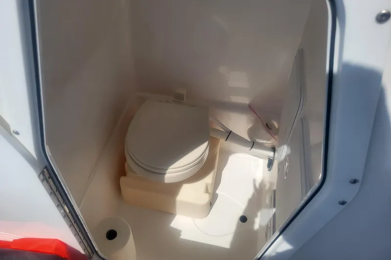 Slide: The Image of 2022 Edgewater 245CC boat interior with compact marine toilet. - 18