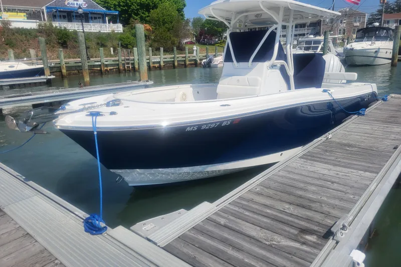 Slide: The Image of 2022 Edgewater 245CC boat docked at marina, featuring sleek design and modern amenities. - 2
