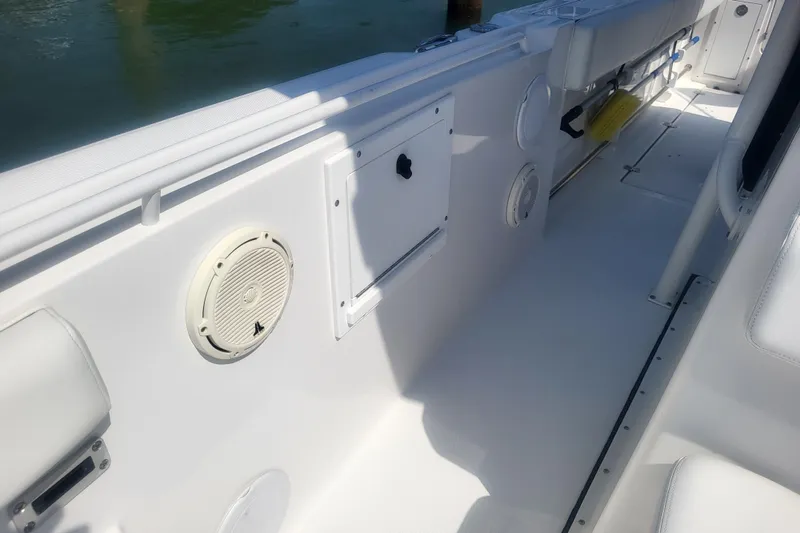 Slide: The Image of Interior view of a 2022 Edgewater 245CC boat, featuring white seating and storage compartments. - 21