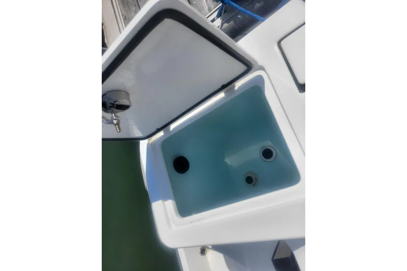 Slide: The Image of Open storage compartment on 2022 Edgewater 245CC boat, showing interior details. - 27