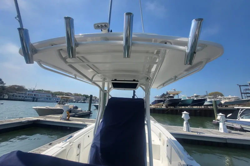 Slide: The Image of 2022 Edgewater 245CC boat docked at marina with clear blue sky. - 30