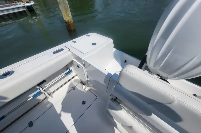 Slide: The Image of 2022 Edgewater 245CC boat interior with white seating and storage compartments. - 33