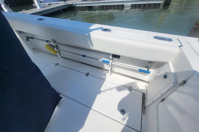 Slide: The Image of 2022 Edgewater 245CC boat interior with storage compartments and dock view. - 34