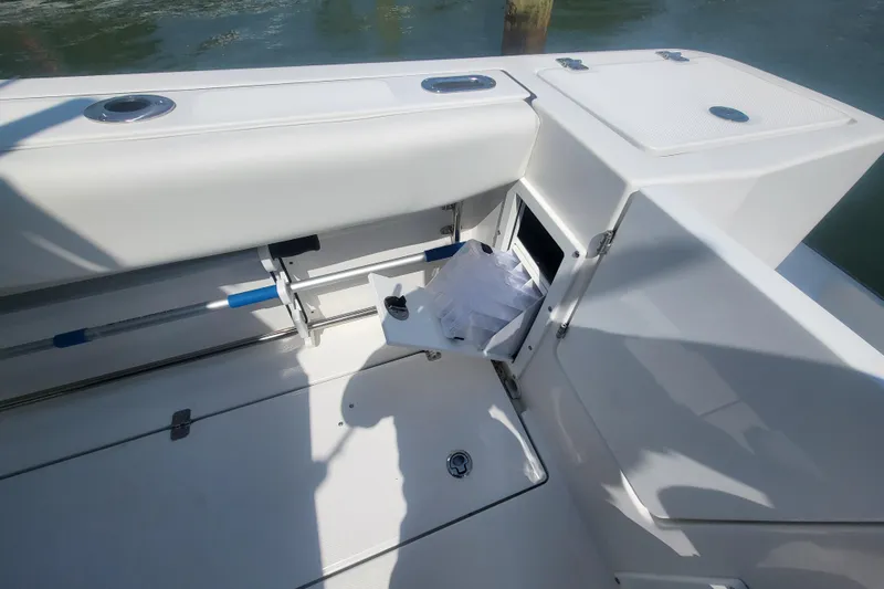 Slide: The Image of 2022 Edgewater 245CC boat interior with storage compartment open, showcasing sleek design. - 36