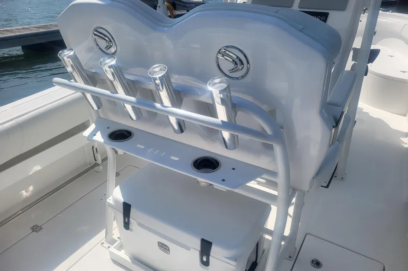 Slide: The Image of 2022 Edgewater 245CC boat interior with rod holders and cooler on deck. - 39