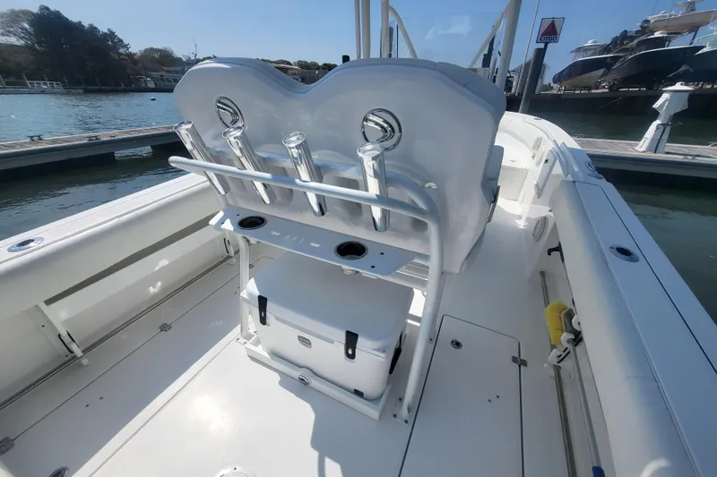 Slide: The Image of 2022 Edgewater 245CC boat interior with seating and storage, docked by the water. - 41