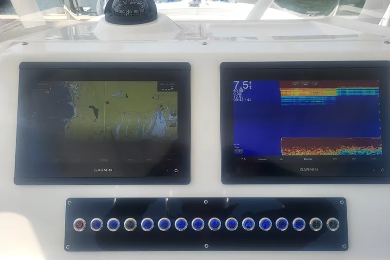 Slide: The Image of Edgewater 245CC 2022 boat dashboard with dual Garmin displays and control panel. - 47