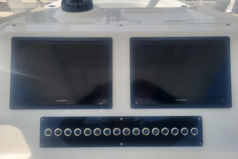 Slide: The Image of Edgewater 245CC 2022 dashboard with dual Garmin displays and control panel. - 48