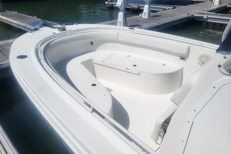 Slide: The Image of 2022 Edgewater 245CC boat interior with spacious seating at the dock. - 5